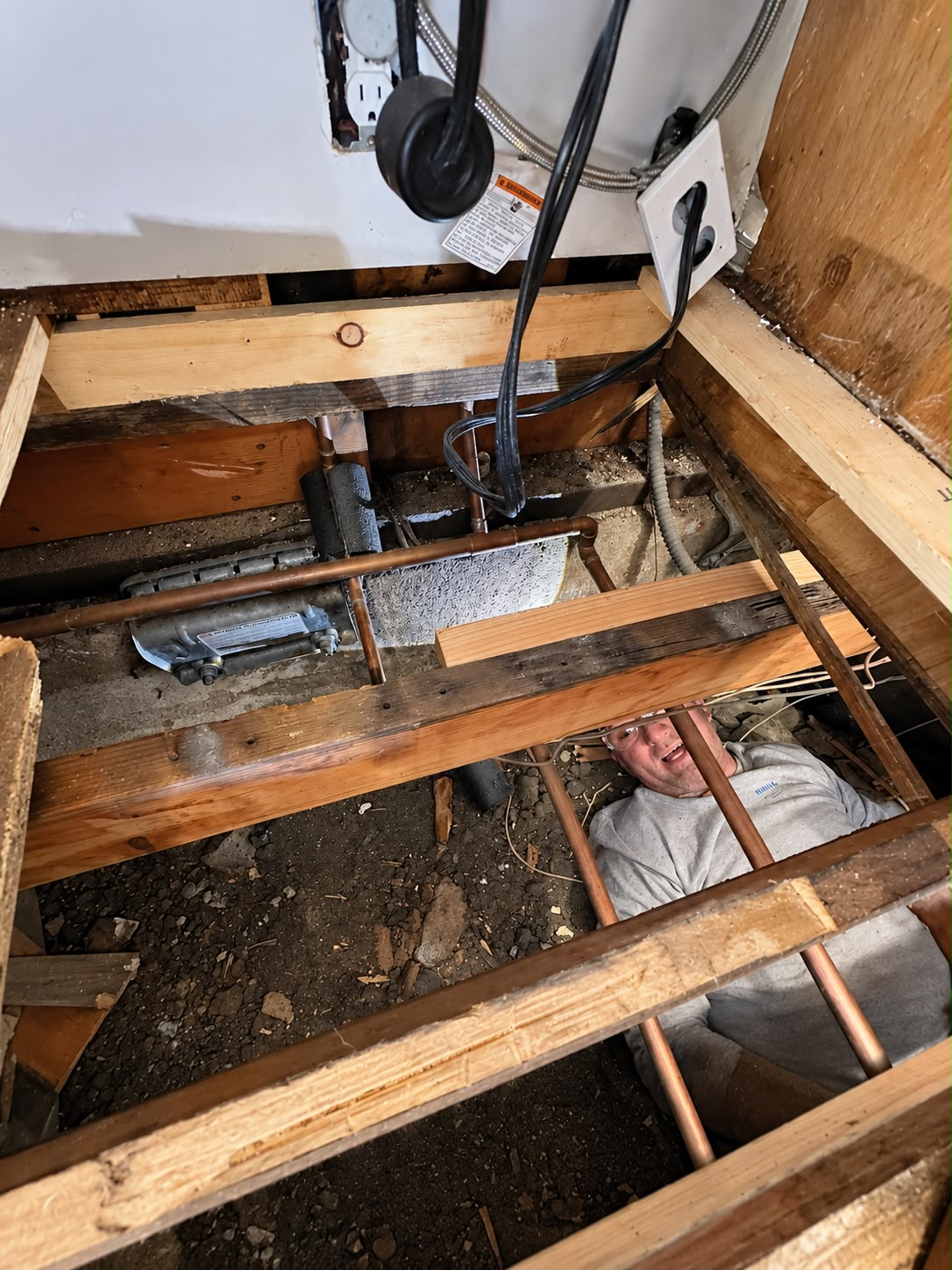 Worker accessing the structure from the crawl space beneath the kitchen