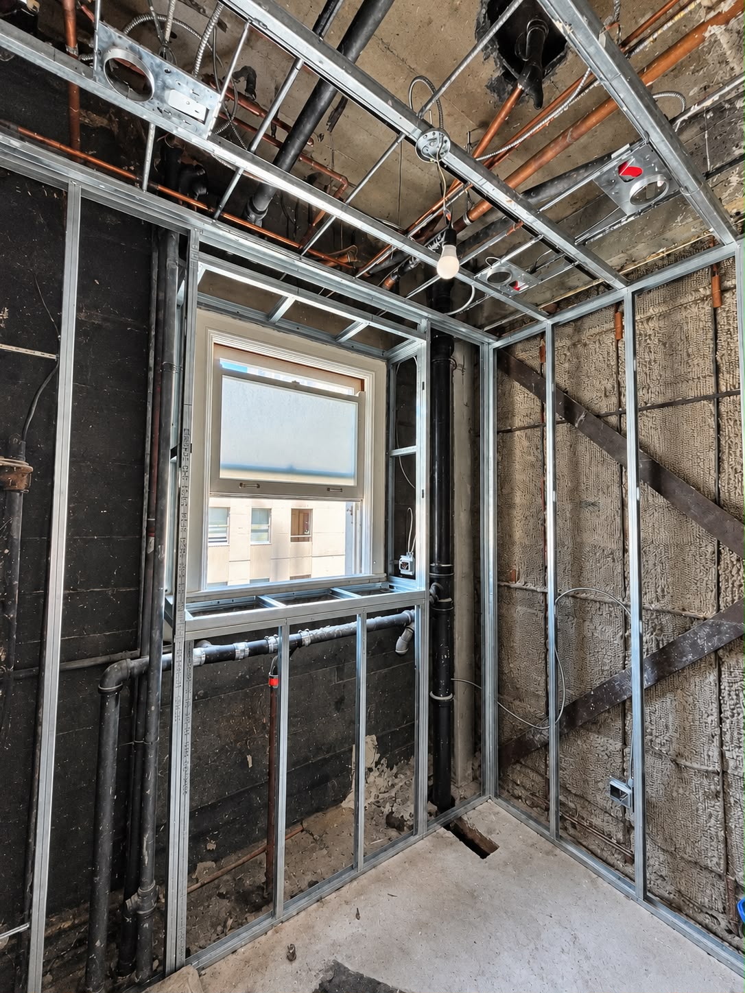 Before: exposed metal framing at the same window corner