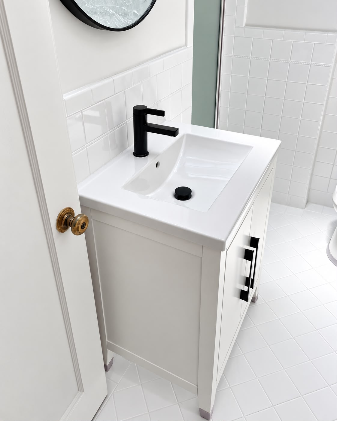 Installed white bathroom vanity with a black faucet and cabinet hardware
