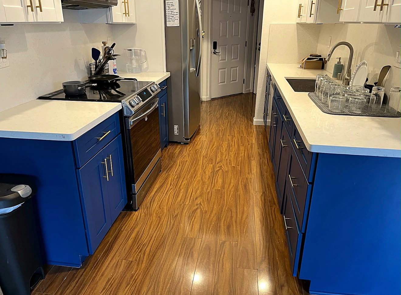 Renovated navy blue lower cabinets with gold handles