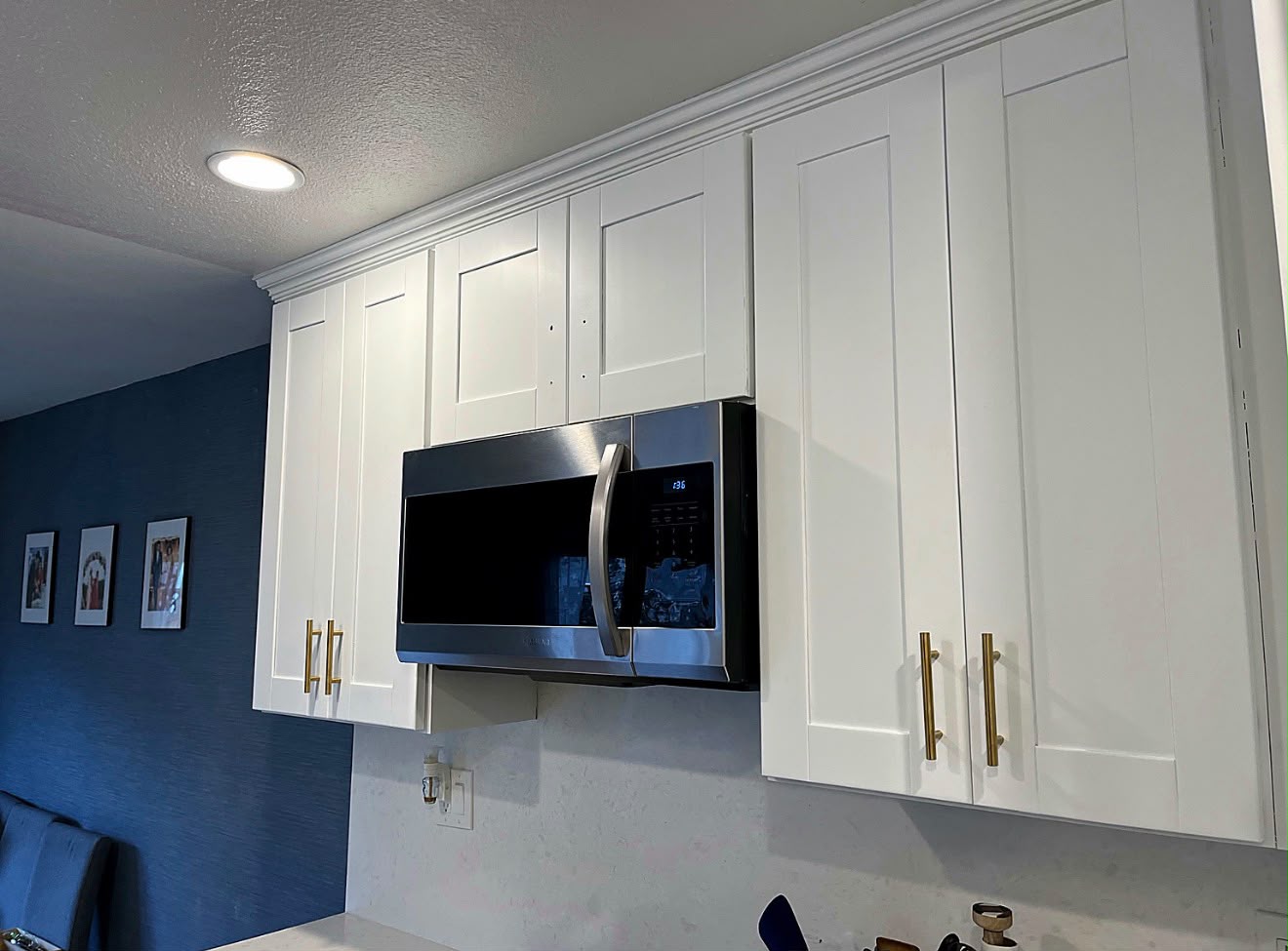 After: renovated white upper cabinets with gold handles