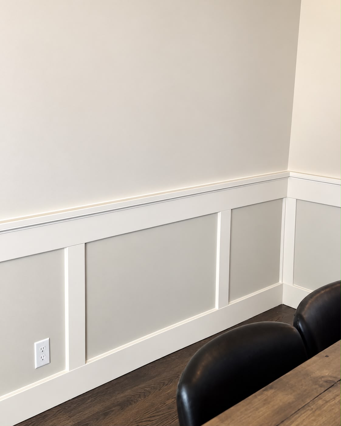 Decorative white wall panel molding continuing neatly around an interior corner